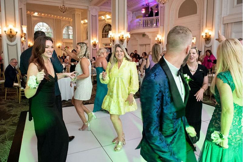 A group of people in formal attire dance and socialize on a white dance floor during SITE Southeast’s Southern Supper Prom Night.
