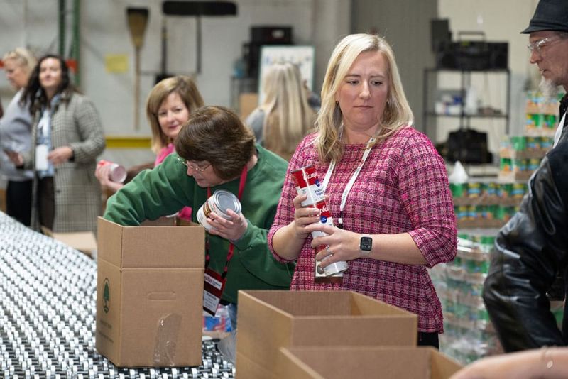 SITE Southeast members packing canned goods for Harvest Hope during the 2024 Education Summit's CSR activities.